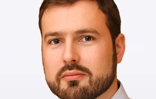 Cyrille Derché in a head-and-shoulders portrait against a pale background.