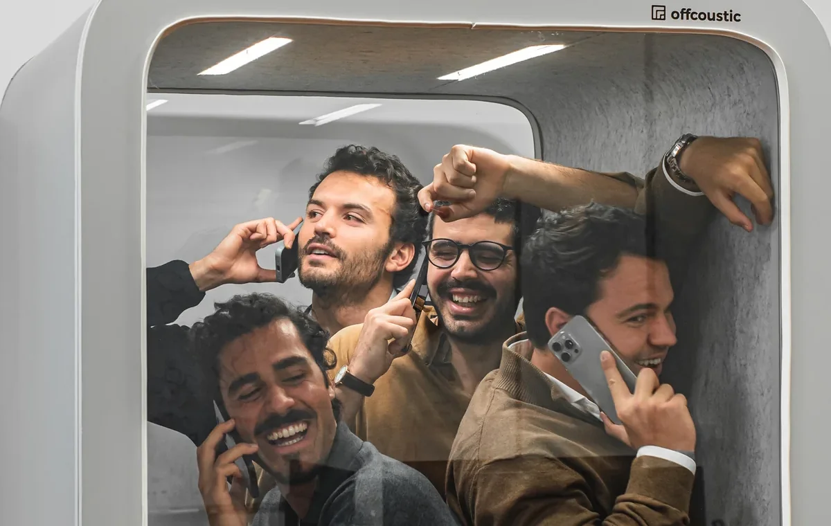 The Offcoustic team crowded into one of their acoustic phone booths, four of them taking calls at once.